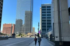 Walking through Downtown Dallas streets between modern skyscrapers