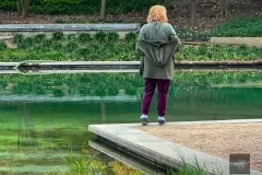 Woman standing near reflective pool in Houston park