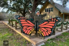 Visitor posing with large monarch butterfly wings in Texas park