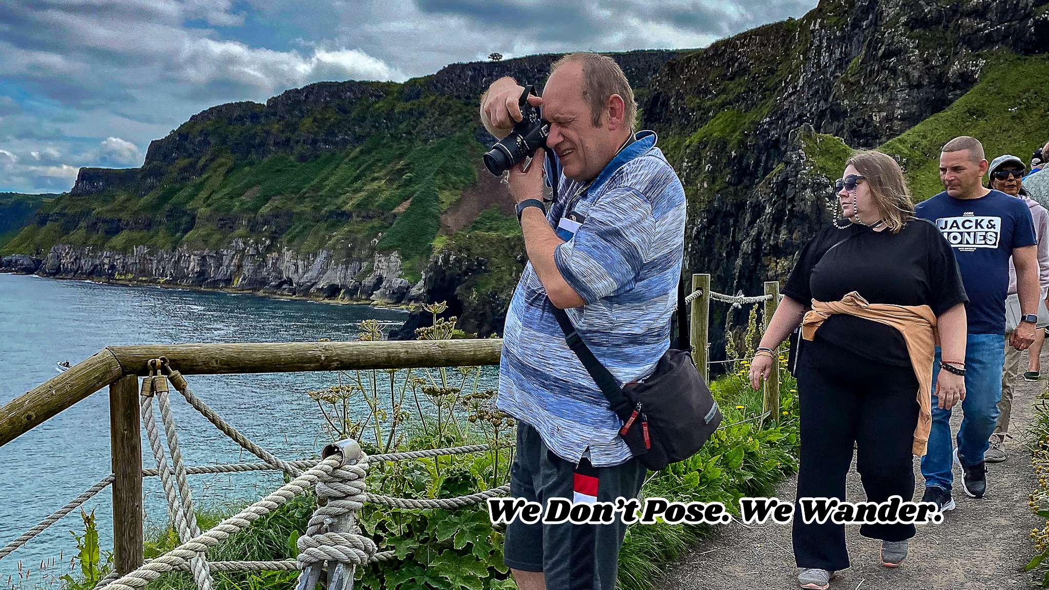 Vagabonds of the North exploring Irish coastal cliffs with camera and ocean backdrop