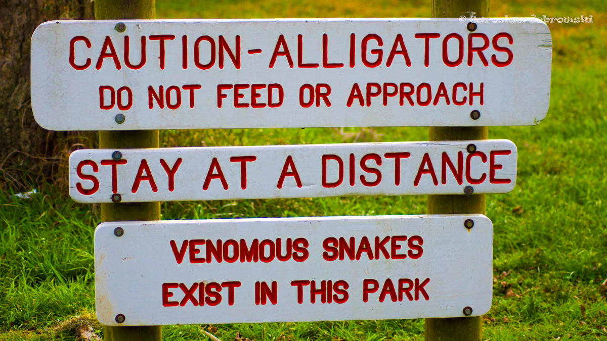 Official Texas Parks warning sign informing visitors about alligators and venomous snakes in Brazos Bend State Park.