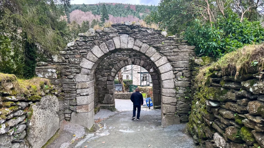 Glendalough ruins entrance with traveler walking through ancient stone gateway